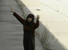 Linda Goode Bryant stands outside of an abaonded factory that will later become Dia Beacon with her arms outstretched.